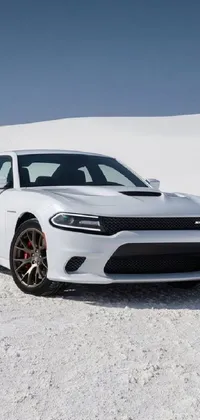 This live phone wallpaper showcases a white Dodge Charger parked in a snowy desert landscape, resembling a bull's avatar