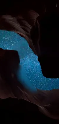 This phone live wallpaper features a close-up view of water with a sky background, enthralling cave painting, stunning space art, and prominent antelope canyon topography
