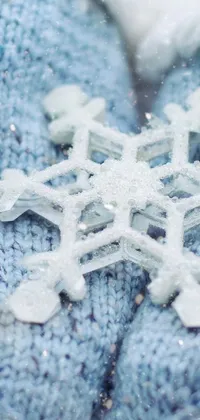 This stunning live wallpaper depicts a captivating illustration of a person holding a snowflake in their hands