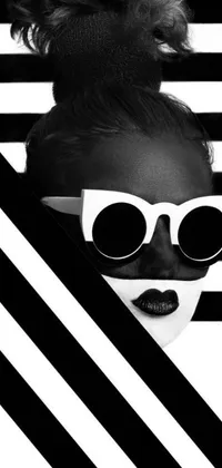 This black and white phone live wallpaper features a mysterious woman wearing sunglasses, set against an op art pattern background with bold black stripes