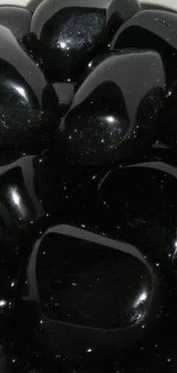 This stunning phone live wallpaper shows a high-resolution image of black Jellybeans on a table, set against an enchanting black night sky