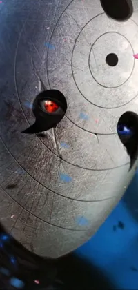 This dynamic live wallpaper showcases a mysterious metallic device with a vivid red eye at its center, emitting piercing laser beams