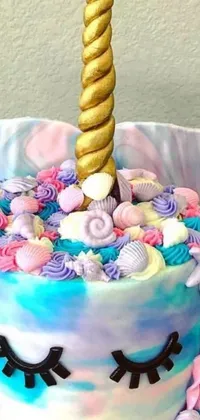 This stunning live wallpaper for your phone features a colorful cake with a unicorn horn on top set against a beautiful ocean backdrop