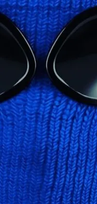 Get mesmerized by this stunning phone live wallpaper available now! Featuring a person wearing a blue sweater and black sunglasses, this design by Tadashi Nakayama boasts detailed clothes texture and a skimask