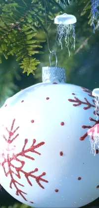 Get in the holiday spirit with this stunning phone live wallpaper featuring a close-up of a Christmas ornament on a tree