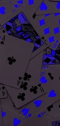 This digital art phone live wallpaper showcases a striking pile of playing cards on a table, complete with dark purple skin and a grey and blue theme