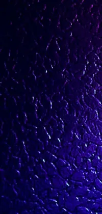 This live wallpaper for your phone features a vibrant image of a plastic shell in shades of purple and blue with a shimmering textured surface