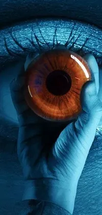 This captivating phone wallpaper offers a digital rendering of an eye with orange pupils and blue light inside
