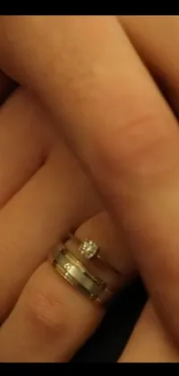 This phone live wallpaper showcases a beautiful wedding ring held by a person's hand