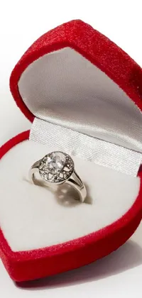 This mobile live wallpaper features a highly detailed diamond ring resting in a red velvet box