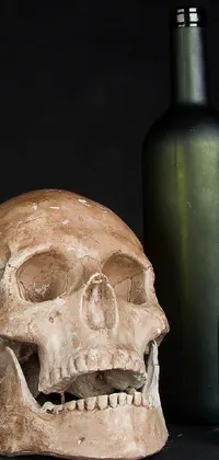 This mobile live wallpaper showcases a skull resting on a wooden table amid glass bottles and miscellaneous objects
