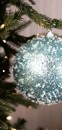This lively phone wallpaper features a close-up of a Christmas ornament on a tree