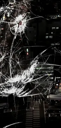 This phone live wallpaper features a black and white photograph of a city at night, viewed through fragmented glass