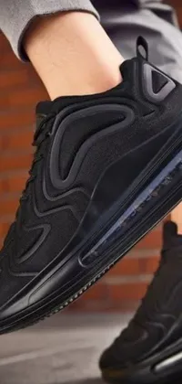 This phone live wallpaper features a close-up view of black sneakers designed for rigorous athletic activities