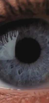 This phone live wallpaper features a stunning close-up of a person's eye in shades of light grey-blue and anamorphic lens distortion
