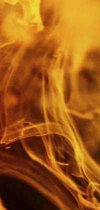 This mesmerizing phone live wallpaper is a high definition image of a vibrant fire with traces of smoke