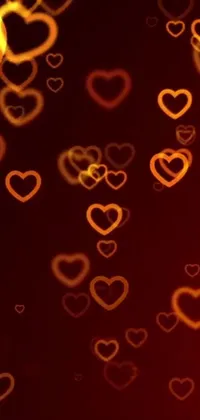 This phone live wallpaper features an array of red hearts on a deep black background, radiating an amber glow that adds a touch of romance to your device