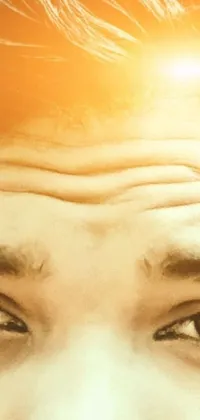 This phone live wallpaper showcases a hyperrealistic close-up of a face with a sun in the backdrop