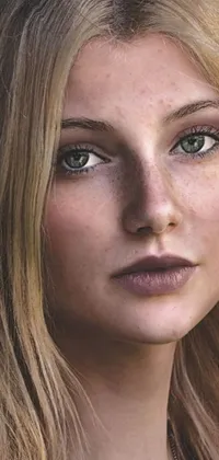 This phone live wallpaper features a close up of a young blonde woman with freckles on her face