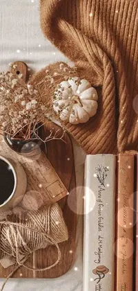 This phone Live Wallpaper features a charming and visually appealing scene of a wooden table adorned with books and a mug of steaming coffee