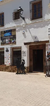 This vibrant mobile live wallpaper portrays a couple of motorcycles parked in front of a rustic building in Costa Blanca