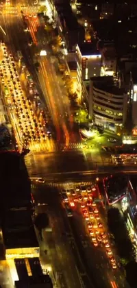 This phone live wallpaper showcases an animated aerial view of a city at night with shimmering street lights, towering skyscrapers, and bustling streets