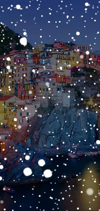 This live wallpaper showcases a snow-covered town with sparkling lights on the cliff side