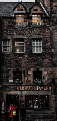 This phone live wallpaper depicts an image of a person standing in front of a tall building, with a stunning Australian tonalism inspired background featuring a medieval tavern and Scotland scenery