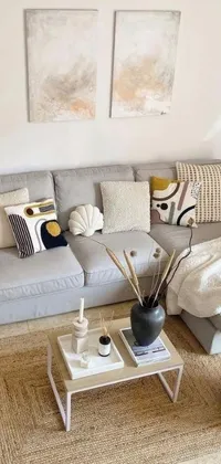 Looking for a cozy and inviting live wallpaper? Look no further than this living room-themed wallpaper! This design features a comfortable couch, a stylish coffee table, and a warm atmosphere highlighted by sandy yellow pillows and indoor house plants