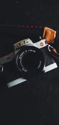 This live wallpaper showcases a vintage-style camera resting on a black table