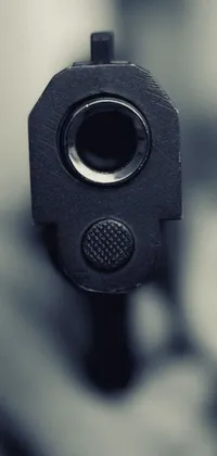 This live phone wallpaper features a black and white close-up image of a gun muzzle by Niko Henrichon