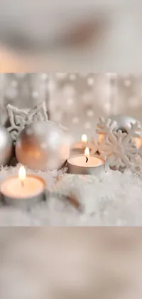 The stunning baroque-inspired live phone wallpaper features a group of fabulous candles positioned beautifully on a serene and snow-covered ground
