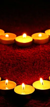 If you're seeking a peaceful and lovely background for your mobile device, you'll adore this heart-shaped candle arrangement on a red blanket live wallpaper