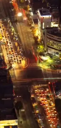Get a bird's eye view of a busy night street in the city with this live wallpaper! It captures the energy of the urban nightlife with cars and people flooding the brightly-lit surroundings
