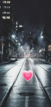This live wallpaper for phones features a heart-shaped object in a rainy night city setting