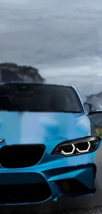 This phone live wallpaper showcases a blue BMW parked in front of a scenic mountain