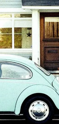 Add some charm to your phone's home screen with this stunning live wallpaper featuring a photorealistic blue Volkswagen Beetle parked in front of a house