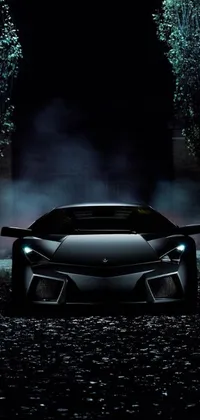 Live Mobile Wallpaper of black sports car racing through forest at night