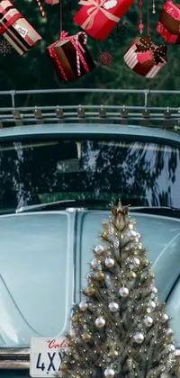 This phone live wallpaper showcases a blue Volkswagen bug parked near a Christmas tree, adding festive cheer to your phone screen