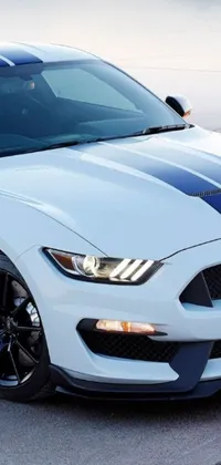 Get ready to impress with this stunning live wallpaper featuring a white Ford Mustang trimmed with a white stripe and parked in a lot