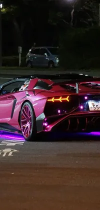 This live wallpaper features a pink sports car parked on a busy street in Tokio