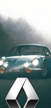 This live wallpaper portrays an image of a blue Renault car driving on a road that runs alongside a dense forest
