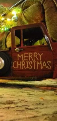 This festive holiday Live Wallpaper features an adorable toy truck parked in front of a beautifully decorated Christmas tree