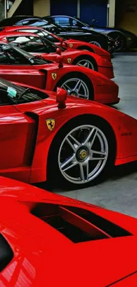 Get ready for some high-octane action with this stunning phone live wallpaper featuring a row of red sports cars parked in a sleek garage