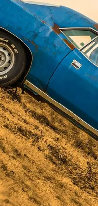 The new phone live wallpaper depicts a vintage blue car parked on a hill