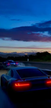 Experience the thrill of the open road with this stunning live wallpaper featuring a sleek red sports car driving down a highway at night