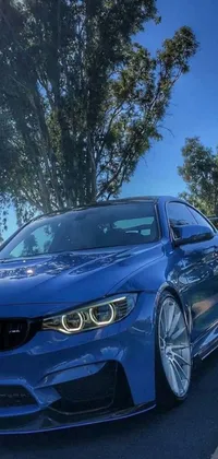 This stunning live wallpaper showcases a highly-detailed blue BMW parked on the side of the road