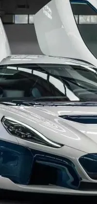 This live wallpaper showcases a clean white and blue sports car parked inside a stylish garage