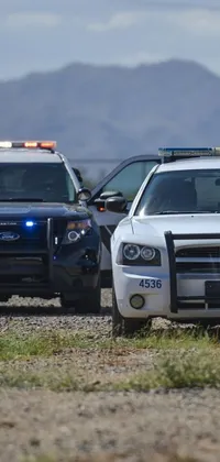 This live wallpaper features two parked police cars in a desert setting
