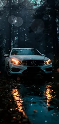 This phone live wallpaper features a luxurious white car driving through a lush forest at night